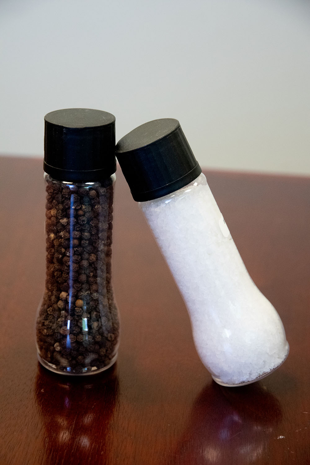 clear salt and pepper shakers on a wood table